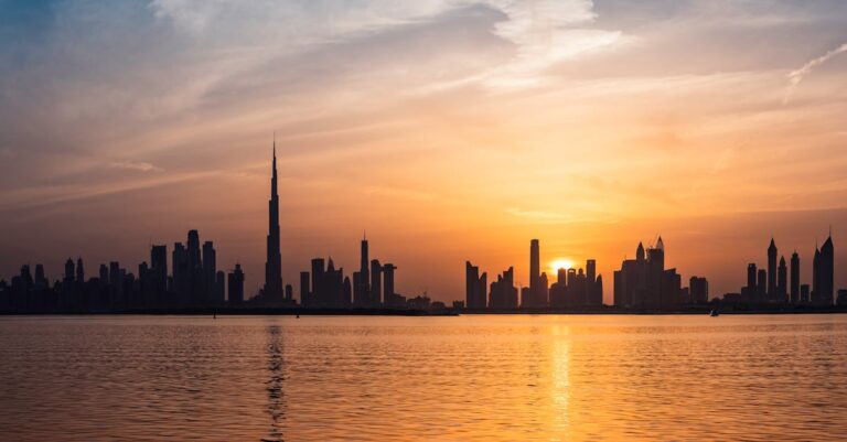 Enchanting view of Dubai's skyscrapers at sunset with the iconic Burj Khalifa outlined against the vivid sky.